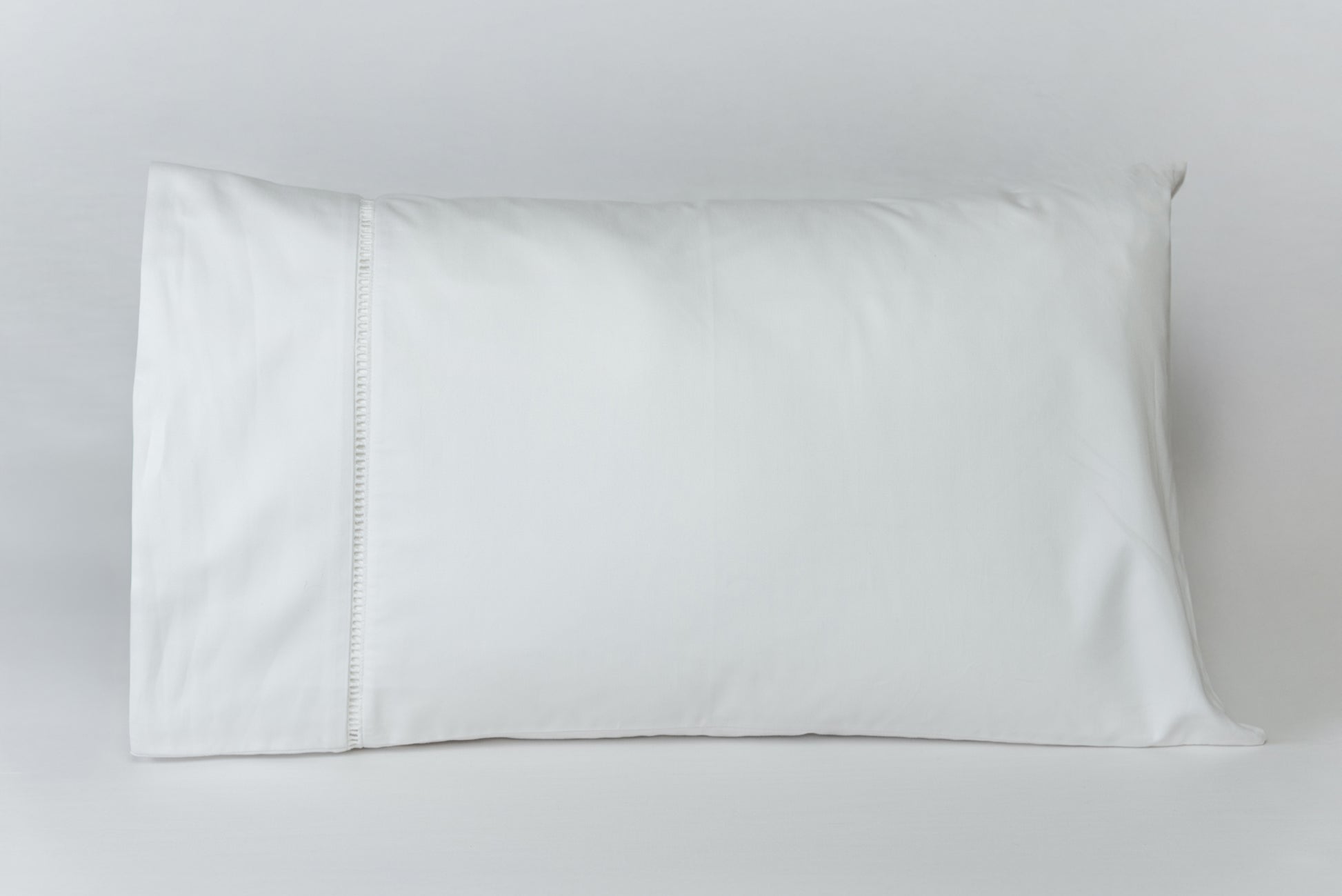 Funda de almohada deshilado de La Casa de los Gansos exhibida sobre fondo blanco, muestra su diseño limpio y natural