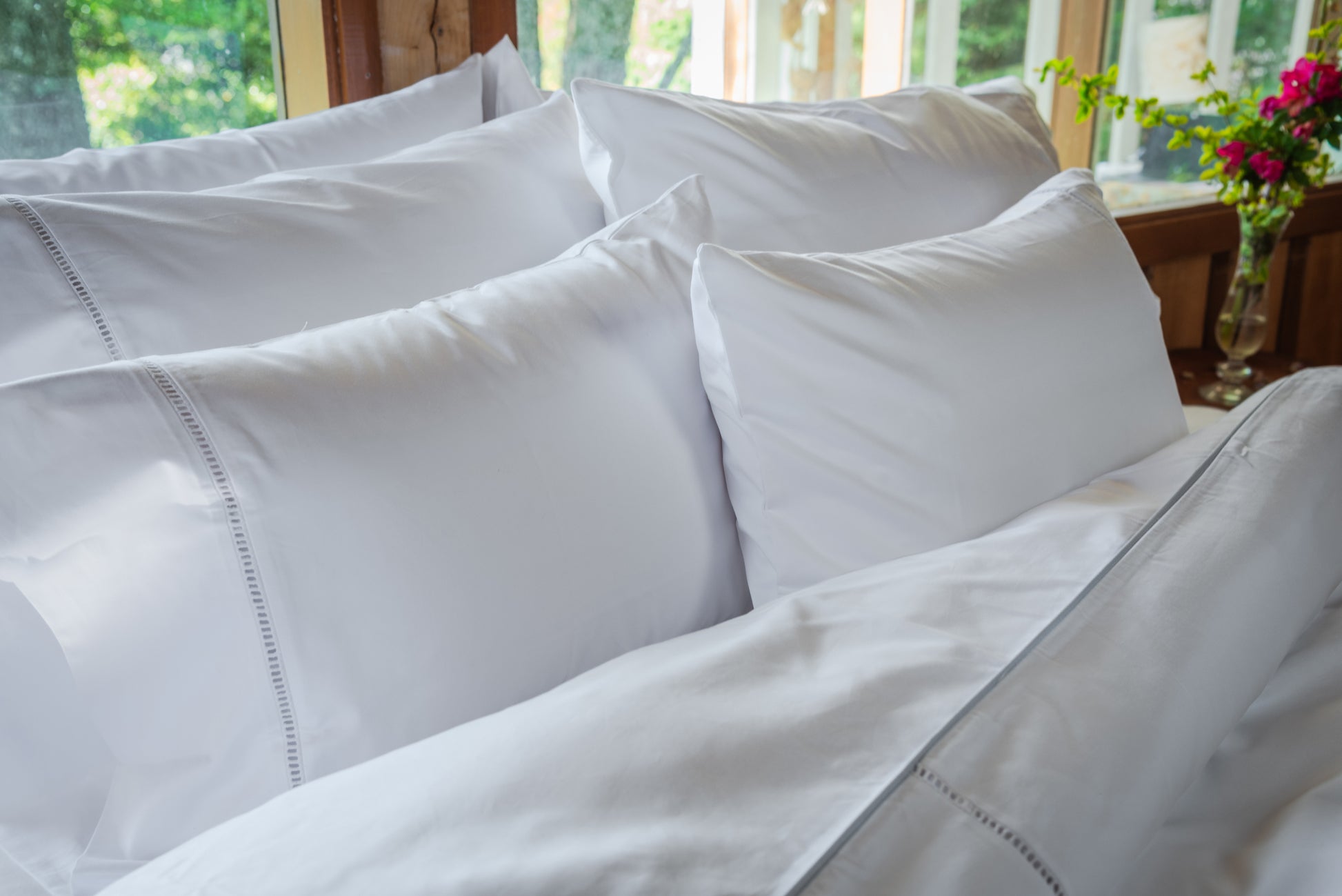 Funda de almohada deshilado de La Casa de los Gansos puesta sobre almohadas, elegante y artesanal