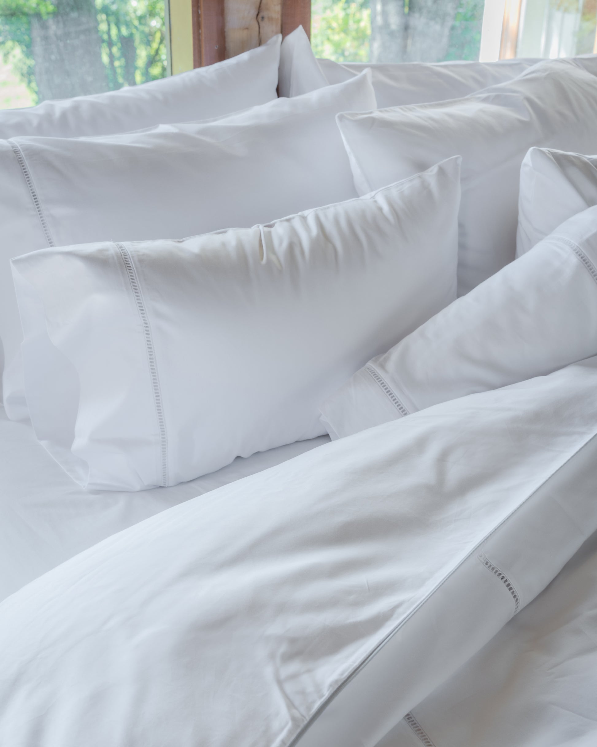 Vista cercana de la funda de almohada deshilado de La Casa de los Gansos, detalle decorativo y suave textura

